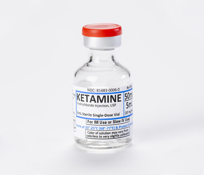 A 50mg/5mL sterile single-dose vial of Ketamine Hydrochloride Solution for injection comparing IM and nasal bioavailability pathways.