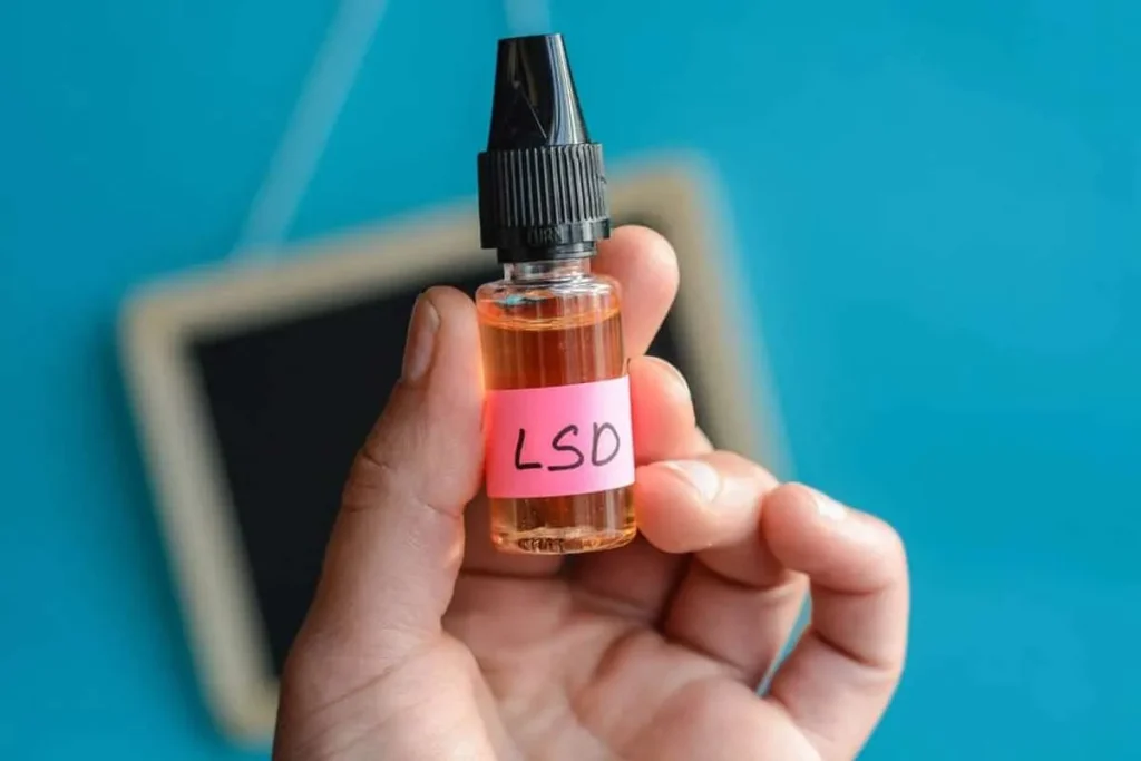 Expert pharmacist holding a laboratory-verified Liquid LSD dropper bottle for precision volumetric dosing calibration