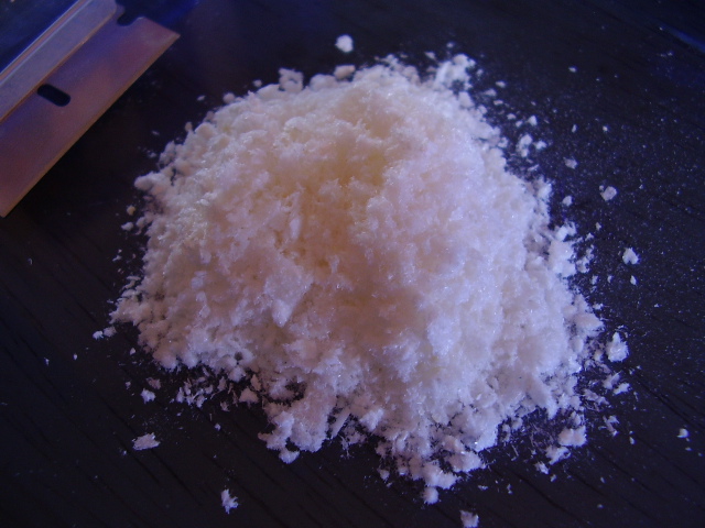 Pure Mescaline HCl powder in crystalline needle form on a dark background for laboratory analysis.