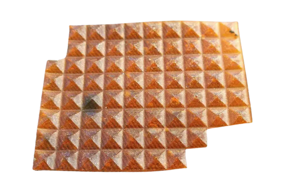 A sheet of amber pyramid-shaped LSD gel tabs isolated on a solid white background.