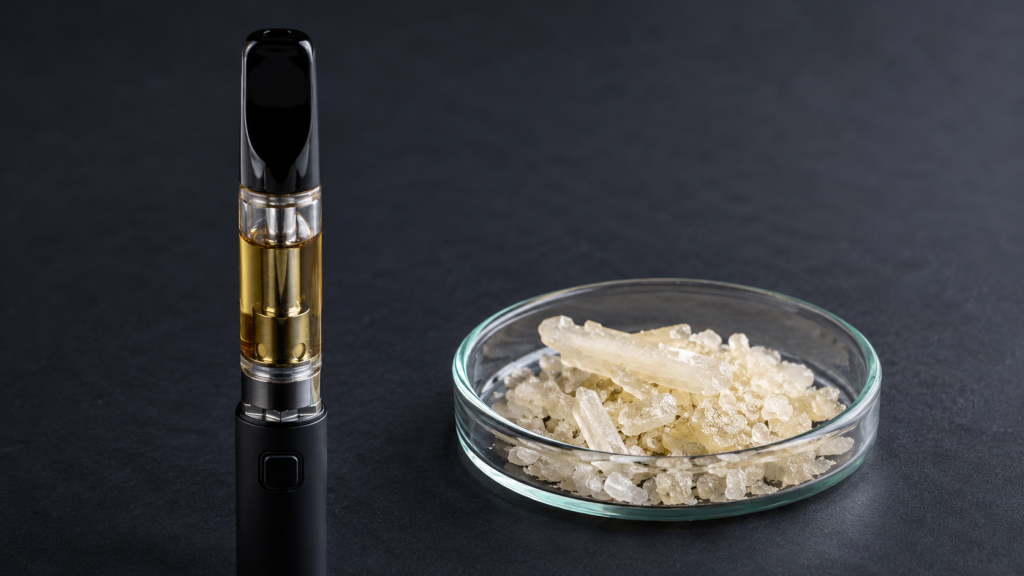 DMT vape pen vs dmt crystal comparison featuring a glass vape cartridge next to a petri dish of freebase dmt crystals