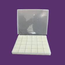 A clear compounding case containing a precise grid of white square Ketamine Troches engineered for slow buccal dissolution.