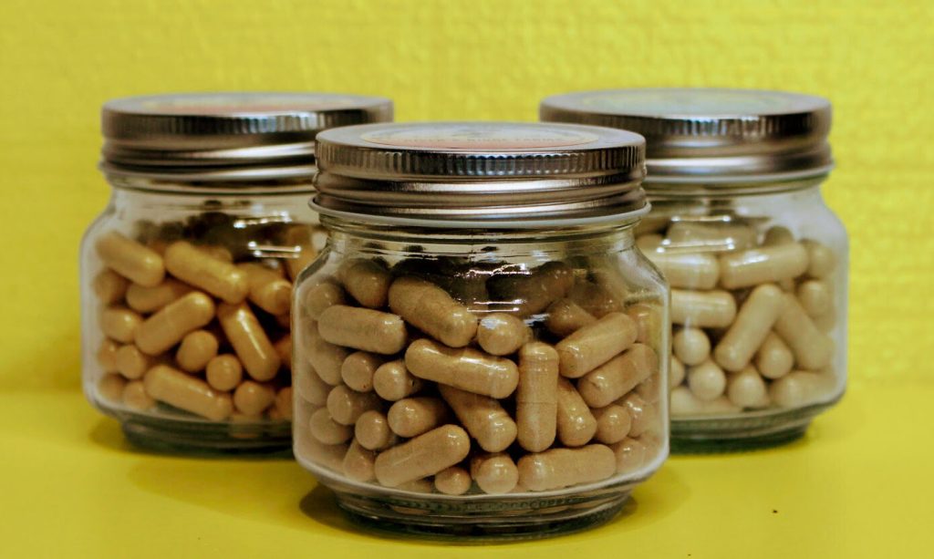 Batch of lab-verified psilocybin mushroom capsules stored in professional glass jars for purity and potency.